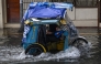 A tricycle wades through a flooded street due to heavy rains brought by the southwest monsoon in Manila on August 9, 2026. (Photo by Jam STA ROSA / AFP)