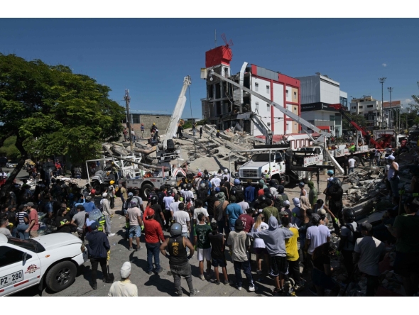 People look for survivors amid the rubble of a collapsed building after an earthquake in Cali, Colombia on August 10, 2026. (Photo by JOAQUIN SARMIENTO / AFP)
