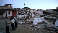 People gather in front of a destroyed house after an earthquake in Colombia on August 11, 2026. AFP file photo.