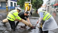 Staff members drain flood water from a water-logged road in Weishi County of Kaifeng, central China's Henan Province, Aug. 11, 2026. (Photo by Li Xinyi/Xinhua)