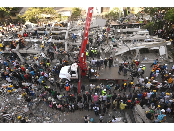 Rescuers and volunteers search for survivors amid the rubble of a collapsed building after an earthquake in Cali, Colombia on August 11, 2026. Photo by JOAQUIN SARMIENTO / AFP