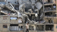 :An internally displaced Palestinian man walks past the rubble of buildings destroyed by Israeli forces in Khan Yunis southern Gaza Strip on August 11, 2026. (Photo by Bashar Taleb / AFP)