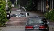 Abandoned cars are seen partially submerged on a flooded road in Sakura, Chiba prefecture on August 14, 2026. Photo by ANDREW CABALLERO-REYNOLDS / AFP