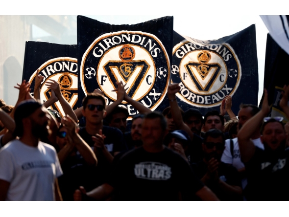 Supporters of French 'Nationale 2' fourth-tier club FC Girondins de Bordeaux wave the club’s flags during a protest ahead of a hearing at the Direction Nationale du Controle de Gestion - DNGG, French football financial watchdog, following the six-time French champions' exclusion from national competitions, in Bordeaux, southwestern France July 19, 2026. Photo by ROMAIN PERROCHEAU / AFP