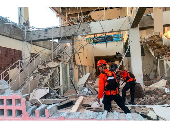 This handout picture taken and released on August 15, 2026 by Indonesia's National Search and Rescue Agency (BASARNAS) shows rescuers working amid the rubble of a damaged building after an earthquake in Maumere, East Nusa Tenggara (Photo by Handout / Indonesia's National Search and Rescue Agency (BASARNAS) / AFP)
