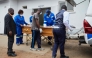 Takemore Malunga (L) watches as pallbearers carry the coffin of his maternal uncle, a victim of the capsized passenger ferry, at the Kariba Hospital mortuary in Kariba, on August 14, 2026. (Photo by Jekesai NJIKIZANA / AFP)