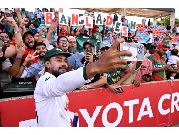 Bangladesh player Mehidy Hasan Miraz poses with fans after victory against Australia on the fourth day of the first cricket Test match between Australia and Bangladesh at Marrara Stadium in Darwin on August 16, 2026. (Photo by William WEST / AFP)