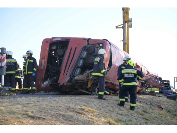 Rescue workers and other officials work at the wreckage of an overturned Polish tourist bus on the M3 motorway near Mezokeresztes, about 150 km east of the Hungarian capital Budapest, on August 16, 2026. Photo by Zoltan MATHE / MTI / AFP