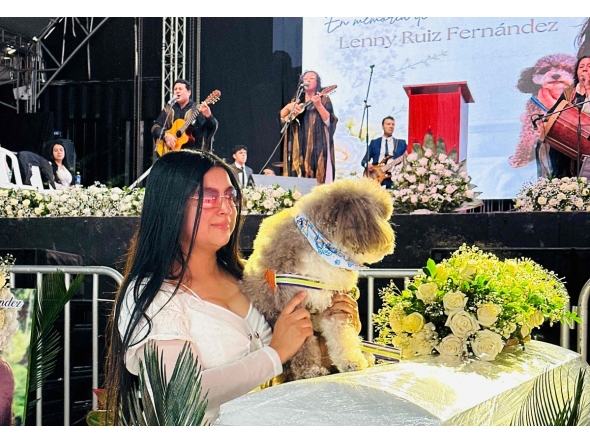 Jessica Florez, sister-in-law of the Colombian lawyer Lenny Ruiz, who died protecting her dog Salomon, during the August 10th earthquake in Cali, holds Solomon during Ruiz's funeral in Pasto, Colombia on August 13, 2026. (Photo by Eyder Portilla / AFP)