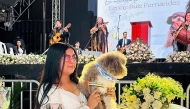 Jessica Florez, sister-in-law of the Colombian lawyer Lenny Ruiz, who died protecting her dog Salomon, during the August 10th earthquake in Cali, holds Solomon during Ruiz's funeral in Pasto, Colombia on August 13, 2026. (Photo by Eyder Portilla / AFP)