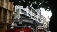 Onlookers and fire personnel gather at the site following a fire at a hotel in Kolkata on August 19, 2026. Photo by Dibyangshu SARKAR / AFP