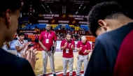 Qatar coach Mounir Ben Zeghala (second right) speaks to players.