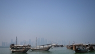 Traditional wooden boats are anchored in front of the Doha skyline on August 19, 2026. (Photo by Mahmud Hams/ AFP)
