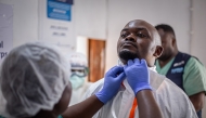 A medical worker puts on a protective suit at an Ebola treatment center in Beni, North Kivu Province, the Democratic Republic of the Congo, Aug. 16, 2026. (Xinhua)