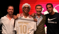 Newly recruited Brazilian football player Ronaldinho poses on stage with the jersey of Ravenna FC next to the president of the club, Ignazio Cipriani (R) during the team presentation in Marina di Ravenna on August 20, 2026. (Photo by Stefano RELLANDINI / AFP)
