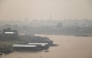 Haze blankets a riverside residential area along the Kahayan River in Palangkaraya, Central Kalimantan, on August 21, 2026, as a result of widespread forest and land fires occurring at various points across the island. (Photo by REINA / AFP)