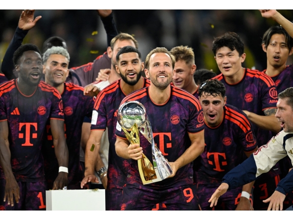 Bayern Munich's English forward #09 Harry Kane (C) holds the trophy as he celebrates with his teammates winning the Franz Beckenbauer Supercup football match between Borussia Dortmund and FC Bayern Munich on August 22, 2026 in Dortmund, western Germany. (Photo by INA FASSBENDER / AFP)