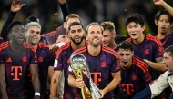 Bayern Munich's English forward #09 Harry Kane (C) holds the trophy as he celebrates with his teammates winning the Franz Beckenbauer Supercup football match between Borussia Dortmund and FC Bayern Munich on August 22, 2026 in Dortmund, western Germany. (Photo by INA FASSBENDER / AFP)