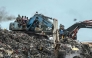 Residents and rescuers use an excavator to search for bodies after a landslide struck the Dar es Salaam dumpsite overnight in Conakry on August 23, 2026. (Photo by AFP)