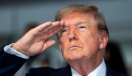 US President Donald Trump salutes during the national anthem at the start of the race, during the Freedom 250 Grand Prix Race on the streets of Washington, DC, on August 23, 2026.(Photo by Doug MILLS / AFP)