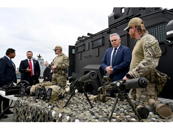 Australian Defence and Border Force officials brief Canadian Minister of Public Safety Gary Anandasangaree (L), US Secretary of Homeland Security Markwayne Mullin (2nd L), and New Zealand Police Minister Mark Mitchell (2nd R) on sniper rifles during a capability demonstration on Garden Island in Sydney on August 26, 2026, at an event held as part of the Five Country Ministerial (FCM) meeting. (Photo by Saeed KHAN / AFP)