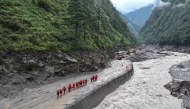 Fire and rescue personnel conduct search and rescue operations on a section of a road leading to Gyirong Port which was damaged after a mudslide two days earlier, in Gyirong County, in China's western Tibet region on August 28, 2026. (Photo by CNS / AFP)