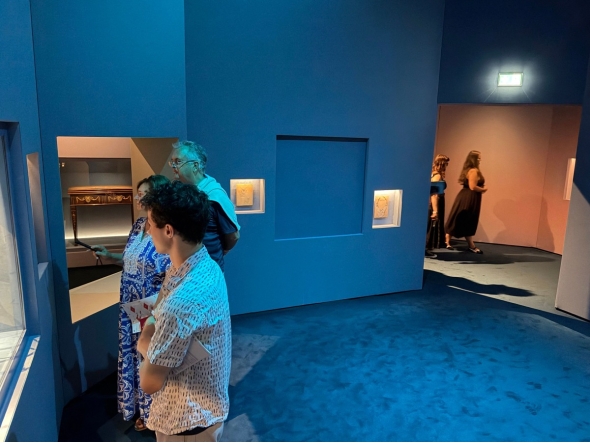 Visitors look at exhibits near a blue panel covering the area where a display case was smashed and a Van Cleef and Arpels necklace was stolen at Vienna's Museum of Applied Arts (MAK), in Vienna, Austria, on August 28, 2026. Photo by Jeremy AUDOUARD / AFP