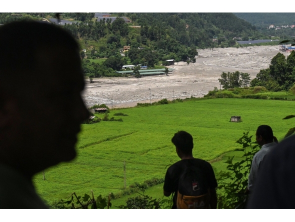 Residents look at the Trishuli River as they take shelter at an elevated place after a flood warning in the Pipaltar area of Nepal's Nuwakot district on August 28, 2026. (Photo by Arun SANKAR / AFP)
