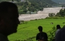 Residents look at the Trishuli River as they take shelter at an elevated place after a flood warning in the Pipaltar area of Nepal's Nuwakot district on August 28, 2026. (Photo by Arun SANKAR / AFP)