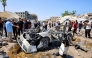 People gather around a destroyed vehicle following an Israeli strike in the Rimal neighbourhood of Gaza City on September 1, 2026. (Photo by Omar AL-QATTAA / AFP)