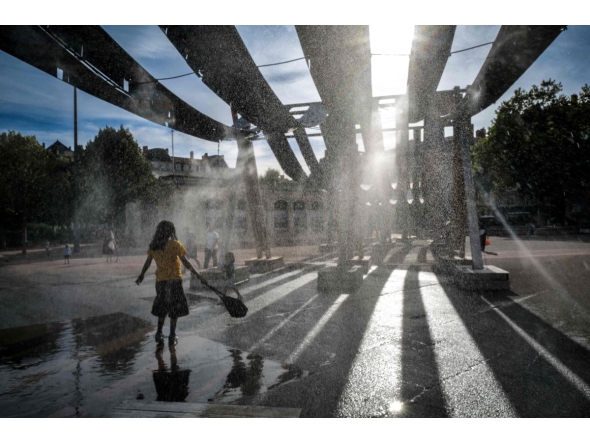 Pedestrians walk through water sprays on Place Bellecour during a heatwave in Lyon, central France on September 2, 2026. (Photo by OLIVIER CHASSIGNOLE / AFP)