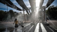 Pedestrians walk through water sprays on Place Bellecour during a heatwave in Lyon, central France on September 2, 2026. (Photo by OLIVIER CHASSIGNOLE / AFP)