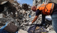 A Civil Defence member collects human remains in the rubble of Al-Muhandisin Tower, that was destroyed in Israeli strikes in the Nuseirat camp for refugees in the central Gaza Strip on September 5, 2026. (Photo by Eyad BABA / AFP)