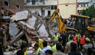 Bulldozers clear debris as rescue personnel conduct a search operation at the site following a building collapse in the Satya Niketan area in New Delhi on September 6, 2026. (Photo by Sajjad HUSSAIN / AFP)