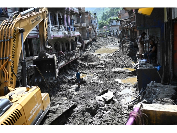 A man operates a backhoe to clean a street in the aftermath of flash floods at Devighat in Nepal's Nuwakot district on September 8, 2026. Photo by Pedro PARDO / AFP