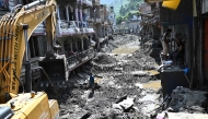 A man operates a backhoe to clean a street in the aftermath of flash floods at Devighat in Nepal's Nuwakot district on September 8, 2026. Photo by Pedro PARDO / AFP