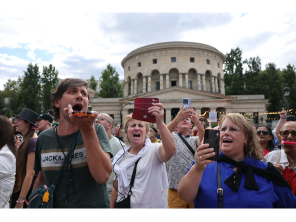 Fans of Canadian singer Céline Dion sing during a “Giant Karaoke” event in her honor in front of the La Rotonde Stalingrad monument in Paris on September 11, 2026, ahead of her concert on September 12. (Photo by Anne-Christine Poujoulat / AFP)