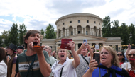 Fans of Canadian singer Céline Dion sing during a “Giant Karaoke” event in her honor in front of the La Rotonde Stalingrad monument in Paris on September 11, 2026, ahead of her concert on September 12. (Photo by Anne-Christine Poujoulat / AFP)