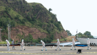 Philippine coast Guard personnel in protective suit carry body bags of victims from a ferry fire blaze to a tent for identification at the port of Borac in Coron, Palawan province on September 12, 2026. (Photo by Ron Lopez / AFP)