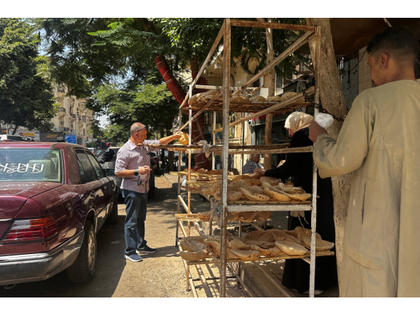 People queue outside a bakery to buy government-subsidised traditional pita bread in Cairo on August 17, 2026. Photo by Khaled Desouki / AFP

