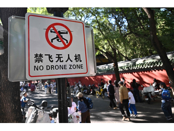 People walk past a sign reading 