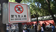 People walk past a sign reading 