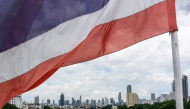 A national flag of Thailand flutters in the wind with the city skyline in the background in Bangkok on September 9, 2026. (Photo by Amaury PAUL / AFP)