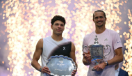 USA's Ben Shelton holds the runner-up trophy next to Germany's Alexander Zverev who holds the winner's trophy after the men's singles final tennis match of the US Open tennis tournament on September 13, 2026. (Photo by Angela Weiss / AFP)
