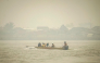 People travel on a river boat as thick haze from forest and land fires blankets Benua Melayu Darat village in Pontianak, West Kalimantan, on September 16, 2026. (Photo by DITO / AFP)