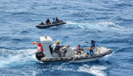 This handout picture taken on September 17, 2026, and released on September 18, 2026 by the Indonesian Navy shows navy personnel maneuvering their boats directly above the passenger ship Virgo Transport 8 which capsized in the Java Sea waters. (Photo by Handout / INDONESIAN NAVY / AFP)