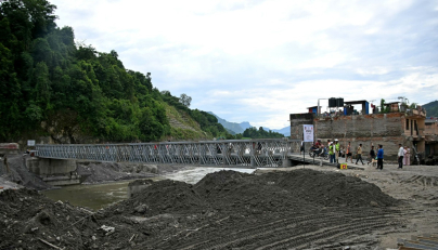 People commute across a bridge over the Tadi river, rebuilt by army personnel in the aftermath of flash floods at Devighat in Nepal's Nuwakot district on September 11, 2026. (Photo by PRAKASH MATHEMA / AFP)
