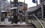 People shield themselves with umbrellas while walking past the metro station entrance in Jongno 3-ga in Seoul on September 20, 2026. (Photo by Lillian SUWANRUMPHA / AFP)