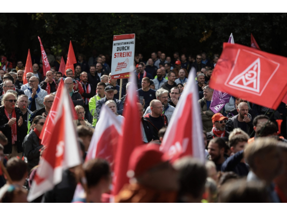 Workers wave flags of the industrial union IG Metall as they protest against job cuts in front of the commercial cars plant of German car maker Volkswagen (VW) on September 21, 2026 in Hanover, central Germany. (Photo by Ronny Hartmann / AFP)