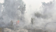 Firefighters extinguish forest and land fires in Banjar, South Kalimantan, on September 21, 2026. Toxic haze has shrouded parts of Indonesia, Malaysia and Singapore for weeks as Jakarta struggles to contain fires that have scorched large tracts of Borneo and Sumatra, with the smoke drifting across the region. (Photo by Muda Sagala/ AFP)
